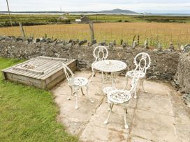 A garden with a table and chairs at Bodlasan Groes House in Holyhead