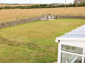 A garden with a table and chairs at Bodlasan Groes House Holyhead