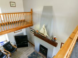 A living room with a fireplace and television at Bodlasan Groes House, Llanfachraeth