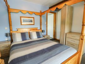 A bedroom with a four-poster bed and furniture at Bodlasan Groes House Llanfachraeth