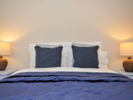 A bed with pillows and lamps at 4 Polgrain Turning St. Wenn near St Columb Major