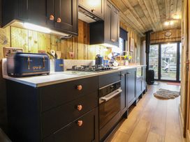 A kitchen with cabinets, sink, and stove at The Suffolk in Knutsford