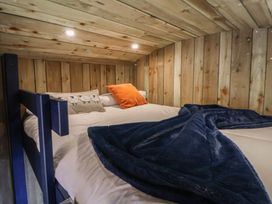 A bedroom with a bed and wooden paneling at The Suffolk in Knutsford