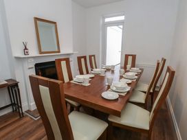 A dining room with a table set for meals at 93 Abbotsbury Road in Weymouth