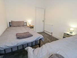 A bedroom with two single beds and a nightstand at 93 Abbotsbury Road in Weymouth
