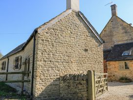 A stone exterior of a cottage with a gate and fence at The Forge Broadway near Stow-On-The-Wold