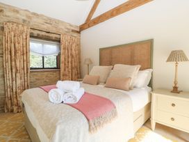 A bedroom with a bed and curtains at The Forge in Broadway near Stow-On-The-Wold