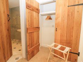 A closet with wooden doors and a clothes hanger at The Forge in Broadway near Stow-On-The-Wold