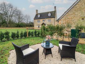 A garden with seating and a house in the background at The Forge in Broadwell near Stow-On-The-Wold