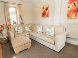 A living room with a sofa and cushions at The Smithy in Stow on the wold