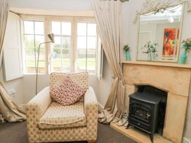A living room with an armchair and fireplace at The Smithy Stow on the wold