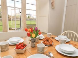 A dining room set with tableware and flowers at The Smithy in Stow on the wold