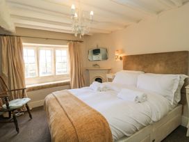 A bedroom with a bed and chair at The Smithy in Stow on the wold