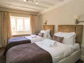 A bedroom with twin beds and a window at The Smithy in Stow on the wold