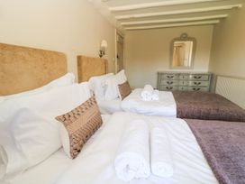 A bedroom with two beds and a dresser at The Smithy in Stow on the wold