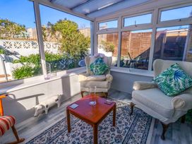 A conservatory with two chairs and a table at 46 Chafeys Avenue