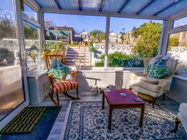 A conservatory with chairs and a table at 46 Chafeys Avenue