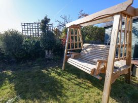 A garden with a wooden swing and trellis at 46 Chafeys Avenue 