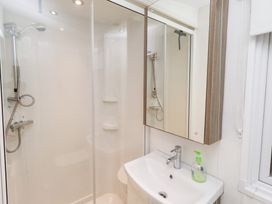 A bathroom with a shower and sink at Chloe's Cabin near Felmoor Holiday Park near Felton