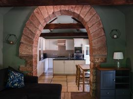 A kitchen with an archway and dining table at Carwinley Mill House Cottage Carwinley near Longtown