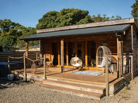 An outdoor area with wooden cabin and seating at The Chard in Carlisle