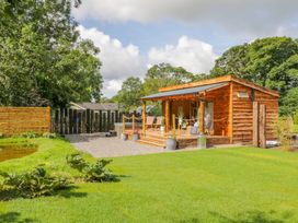 A wooden cabin with chairs and plants outside at The Chard in Carlisle