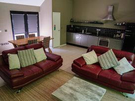 A living room with a sofa and dining area at The Heronry in Carlisle