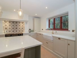 A kitchen with cabinets and an oven at Manor Cottage in Carterton, Oxfordshire