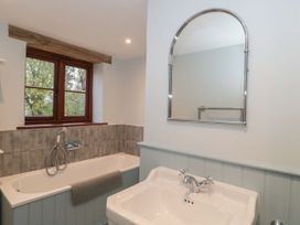 A bathroom with a bathtub and sink at Manor Cottage, Carterton, Oxfordshire