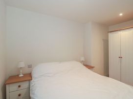 A bedroom with a bed and nightstands at Manor Cottage Carterton, Oxfordshire
