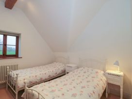 A bedroom with two beds and a window at Manor Cottage, Carterton, Oxfordshire