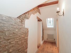 A hallway with stone wall and window at Manor Cottage in Carterton, Oxfordshire