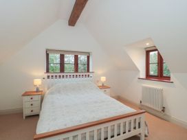 A bedroom with a bed and bedside tables at Manor Cottage in Carterton, Oxfordshire
