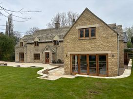 A house with windows and doors in a garden at Manor Cottage in Bampton, Oxfordshire