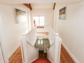 A hallway with a staircase and a window at Rock House in Narberth