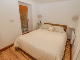 A bedroom with a bed and window at Rock House in Narberth