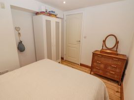 A bedroom with a bed and dresser at Rock House, Narberth
