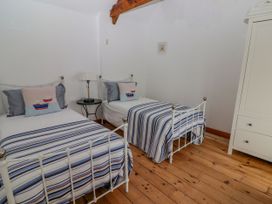 A bedroom with two beds and a lamp at Rock House in Narberth