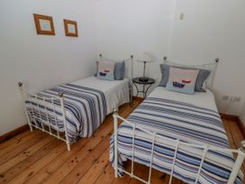 A bedroom with two single beds and a nightstand at Rock House in Narberth