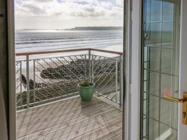 A balcony with a plant pot overlooking the sea at Rock House in Narberth