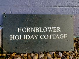 A sign for Hornblower Holiday Cottage with pebbles at Hornblower Lodge in Whitby