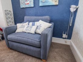 An armchair with cushions in the living room at Hornblower Lodge in Whitby