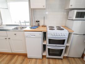 A kitchen with a sink, dishwasher, stove, and oven at Hornblower Lodge in Whitby