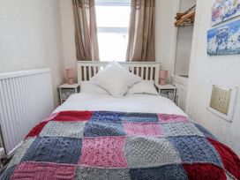 A bedroom with a bed and decorative blanket at Hornblower Lodge in Whitby