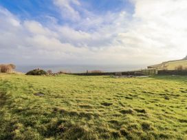 A garden with grass and a view of the ocean at Hornblower Lodge in Whitby