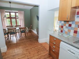A kitchen with a dining area and wooden furniture at Kenvor, Newport, Pembrokeshire