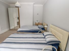A bedroom with two beds and a bedside table at Kenvor, Newport, Pembrokeshire