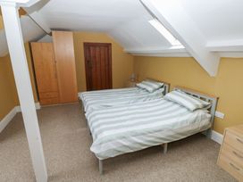 A bedroom with two beds and a wardrobe at Kenvor Newport, Pembrokeshire