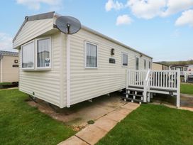 A mobile home with a porch and satellite dish at 82 Manorbier Park in Manorbier