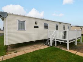 A mobile home with a deck and steps at 82 Manorbier Park in Manorbier